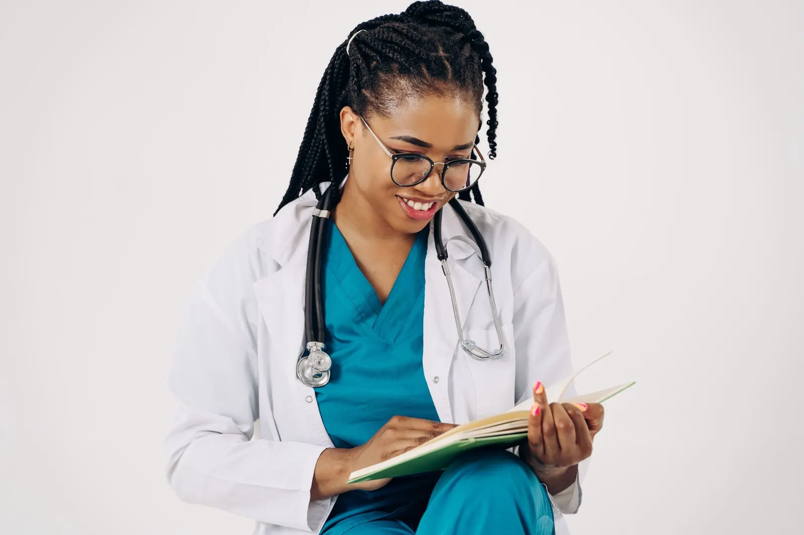 Smiling female doctor in a white coat reading patient notes